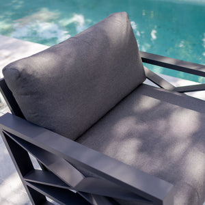 Outdoor furniture collection featuring aluminium outdoor lounge chair, two-seater, and three-seater sofas in charcoal or white, next to a swimming pool.
